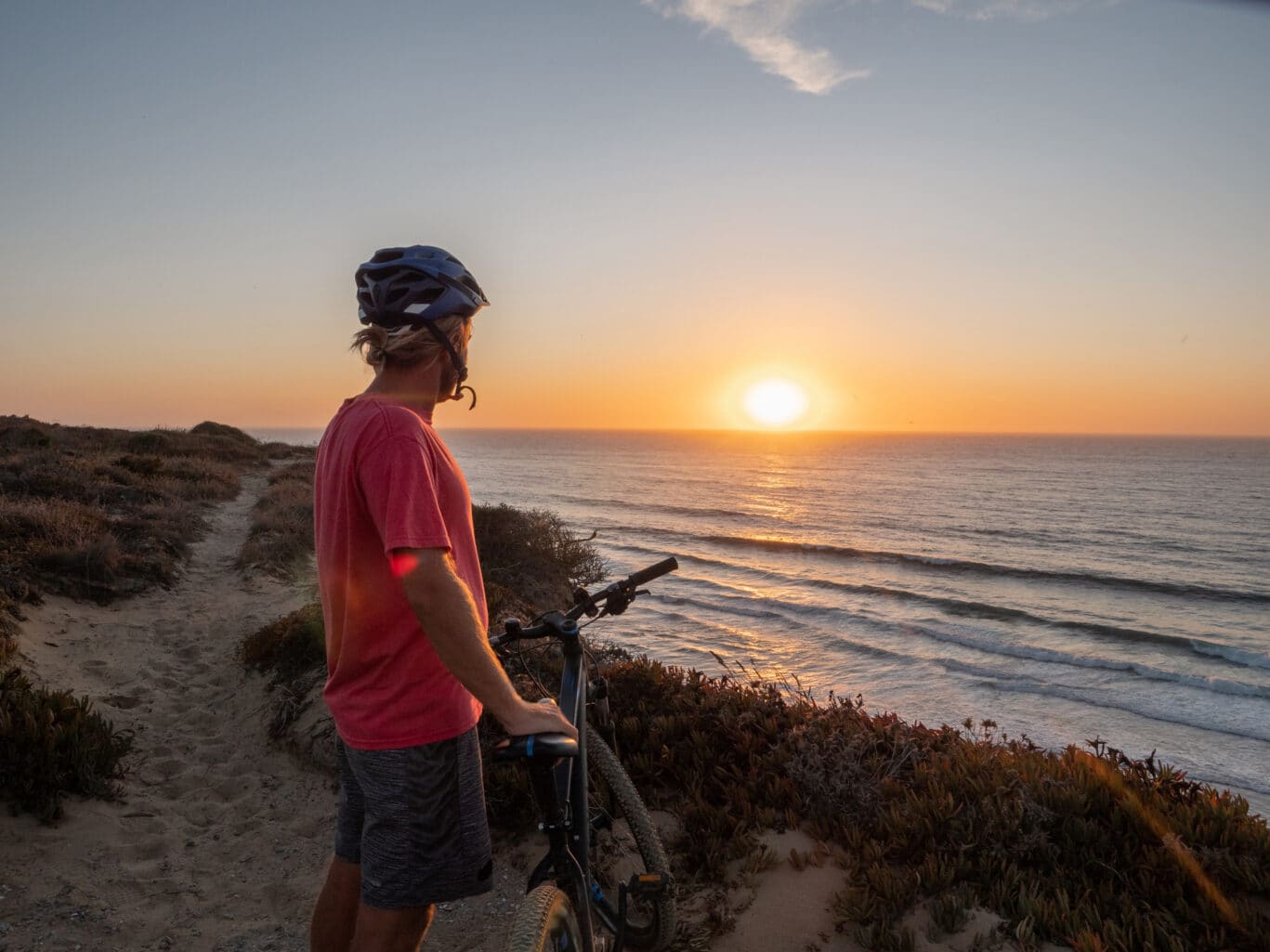 Mountain biker enjoying sunset from cliff