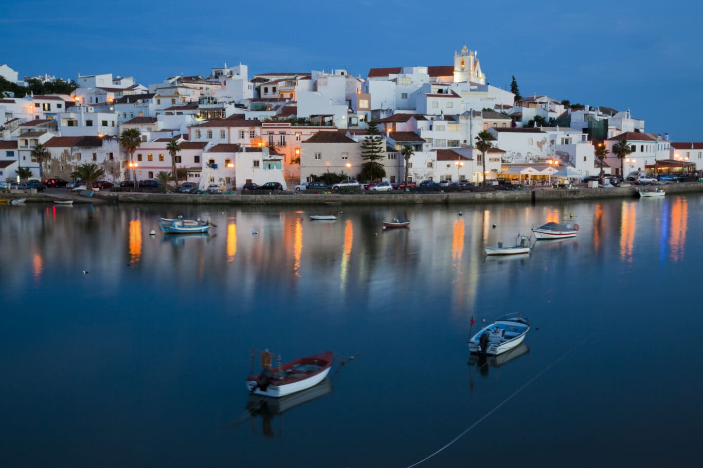 Water view of illuminated cityscape of Ferragudo in Algarve