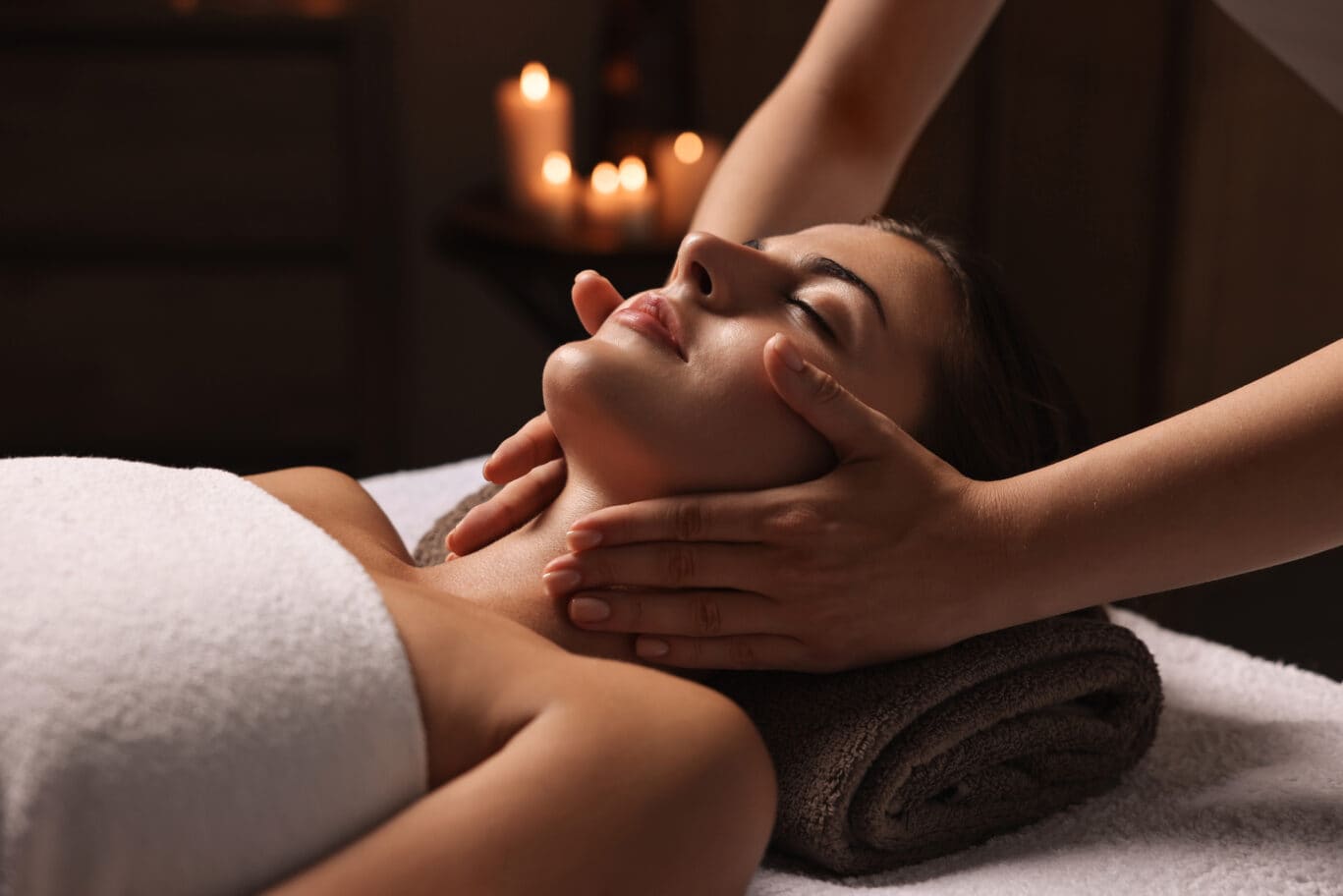 Attractive woman enjoying face massage, closeup.